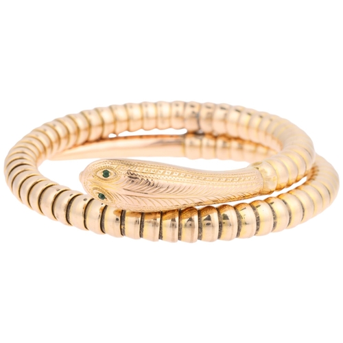 1102 - An early/mid-20th century 9ct gold figural coiled snake bangle, set with green glass eyes and engrav... 