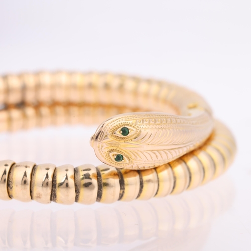 1102 - An early/mid-20th century 9ct gold figural coiled snake bangle, set with green glass eyes and engrav... 