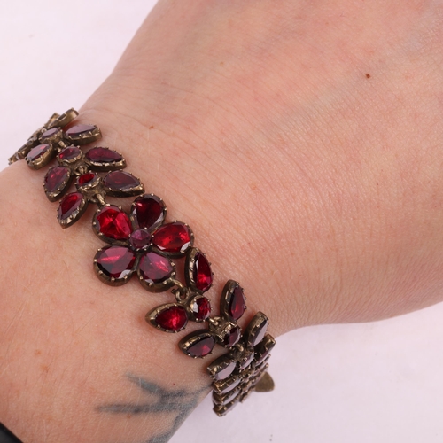 1122 - A Georgian flat-top garnet floral wreath bracelet, circa 1780, the central flowerhead motif flanked ... 