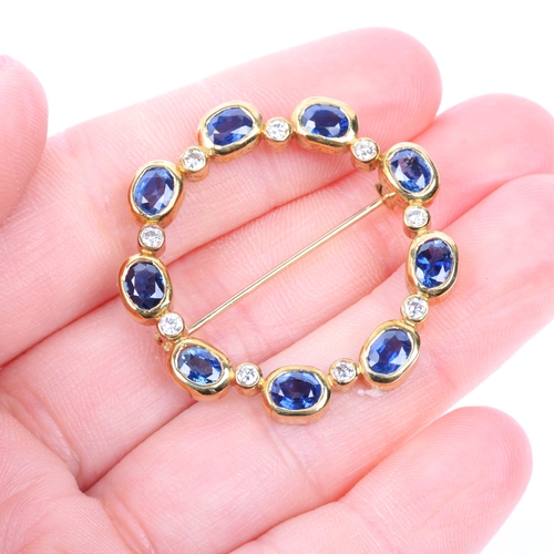 1138 - A late 20th century sapphire and diamond wreath brooch, rub-over set with modern round brilliant-cut... 