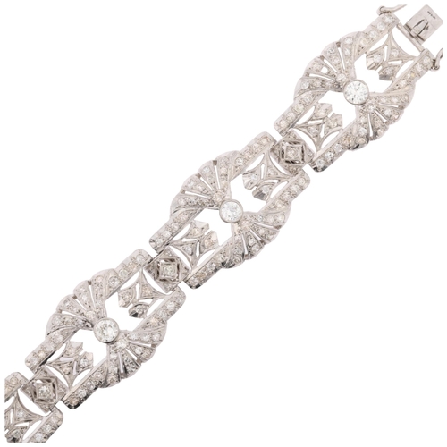 1154 - An Art Deco platinum and diamond panel bracelet, circa 1920s, the 6 panels having openwork fan decor... 