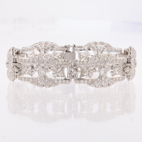 1154 - An Art Deco platinum and diamond panel bracelet, circa 1920s, the 6 panels having openwork fan decor... 