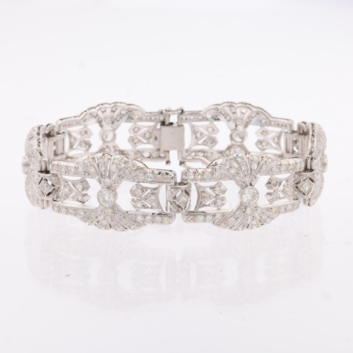 1154 - An Art Deco platinum and diamond panel bracelet, circa 1920s, the 6 panels having openwork fan decor... 