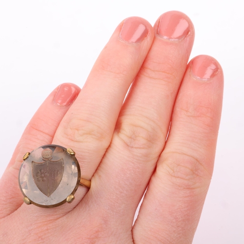 1166 - A late 20th century 9ct gold smoky quartz armorial seal ring, the round smoky quartz intaglio carved... 