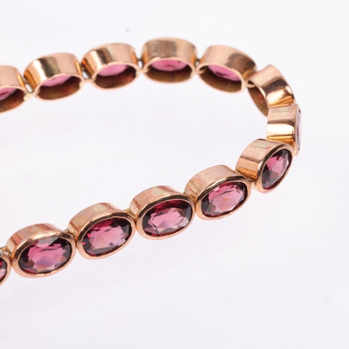 1231 - A modern 9ct rose gold garnet tennis line bracelet, maker SA, London 2009, rub-over set with oval mi... 