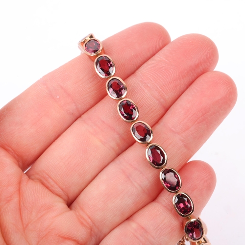 1231 - A modern 9ct rose gold garnet tennis line bracelet, maker SA, London 2009, rub-over set with oval mi... 