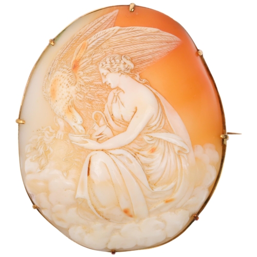 1253 - A large Victorian shell cameo brooch, relief carved depicting Hebe feeding eagle Zeus, in unmarked g... 