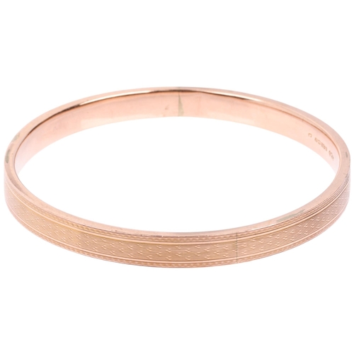 1362 - An early 20th century 9ct rose gold plain slave bangle, maker S&P, Birmingham 1929, allover engine t... 