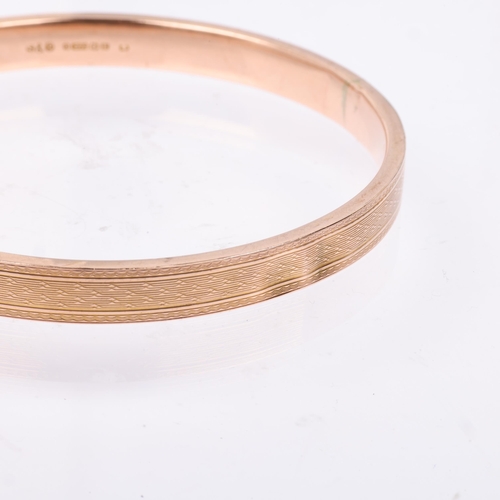 1362 - An early 20th century 9ct rose gold plain slave bangle, maker S&P, Birmingham 1929, allover engine t... 