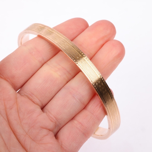 1362 - An early 20th century 9ct rose gold plain slave bangle, maker S&P, Birmingham 1929, allover engine t... 