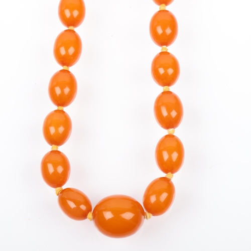 1411 - A long single-strand graduated amber bead necklace, beads ranging from 12.0 - 12.6mm, necklace 74cm,... 