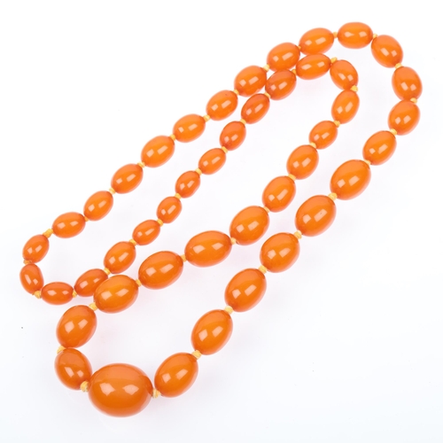 1411 - A long single-strand graduated amber bead necklace, beads ranging from 12.0 - 12.6mm, necklace 74cm,... 