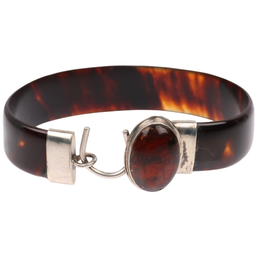 1434 - An early 20th century tortoiseshell and amber torque bangle, band width 12.8mm, internal circumferen... 