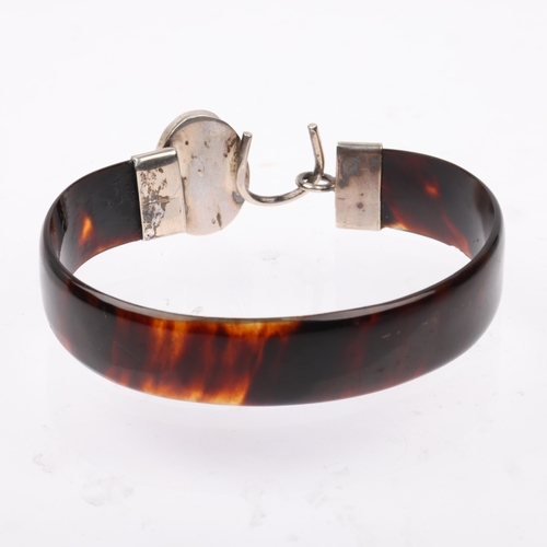 1434 - An early 20th century tortoiseshell and amber torque bangle, band width 12.8mm, internal circumferen... 