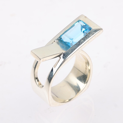 1453 - A modern sterling silver blue topaz crossover ring, London 2023, band width 11.4mm, size P, 13g