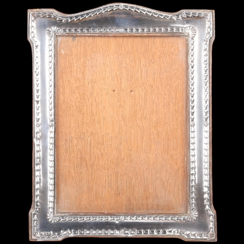 1671 - An Edwardian silver-fronted photo frame, WJ Myatt, Birmingham 1909, shaped rectangular form with rel... 