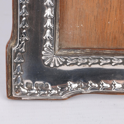 1671 - An Edwardian silver-fronted photo frame, WJ Myatt, Birmingham 1909, shaped rectangular form with rel... 