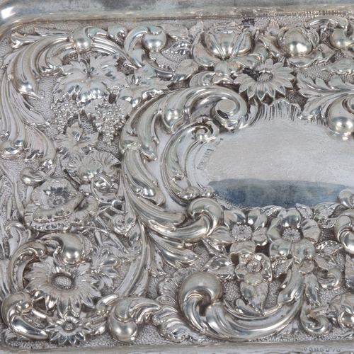 1724 - An Edwardian silver dressing table tray, Walker & Hall, Sheffield 1904, allover high relief embossed... 