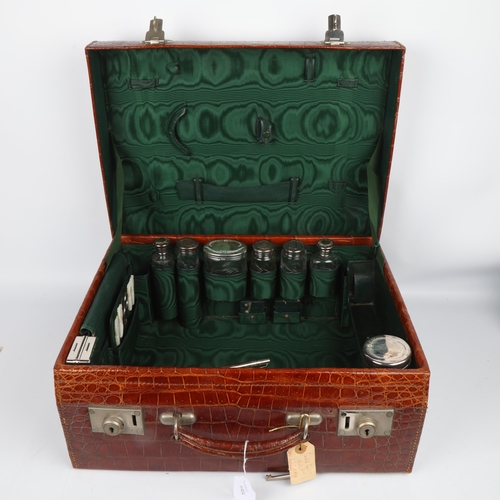 1735 - A Fine quality Art Deco crocodile skin travelling vanity case, with green interior lining, silver-mo... 