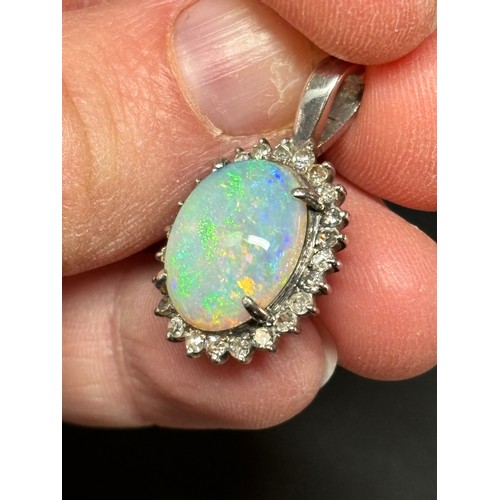 1148 - A late 20th century opal and diamond oval cluster pendant, claw set with 3ct oval cabochon opal surr... 