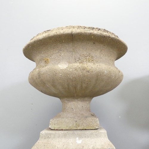 75 - A pair of weathered concrete garden urns on plinth bases. Overall 45x66cm.