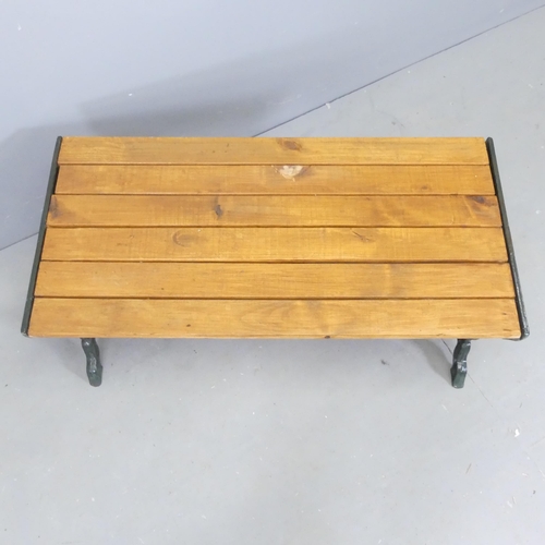 76 - A slatted pine low table / bench with painted cast iron ends. 88x40x44cm.