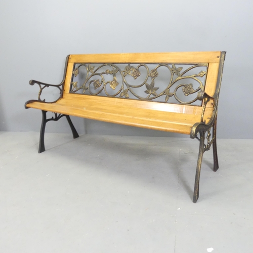 89 - A modern pine slatted garden bench, with cast metal ends and inset gilded metal floral design back. ... 