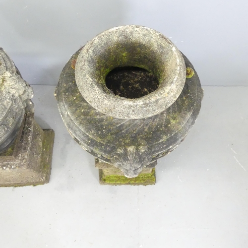 118 - A pair of three-section weathered stone garden urns on plinth stands, with swag and lion mask decora... 