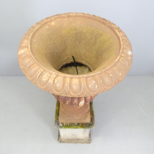 32 - A large Victorian cast iron Campana style urn on stone plinth base. 59x126cm.