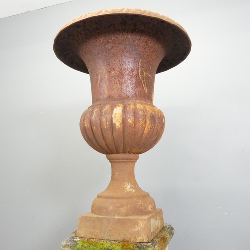 32 - A large Victorian cast iron Campana style urn on stone plinth base. 59x126cm.