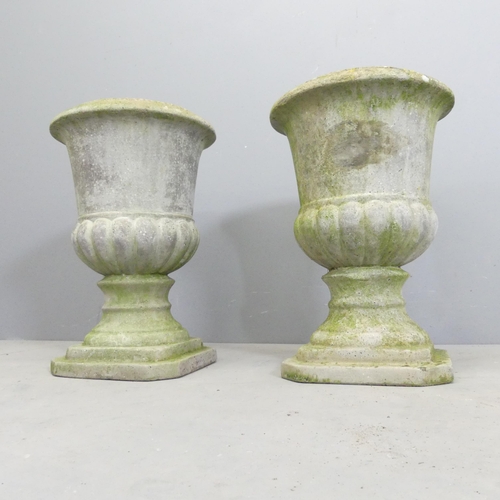 122 - A pair of weathered concrete garden urns. 32x46cm.