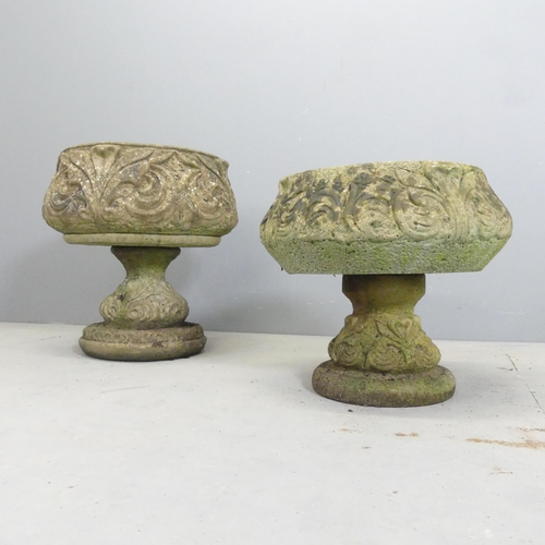 127 - Two similar weathered concrete garden urns on stands, with acanthus leaf decoration. Largest 45x48cm... 