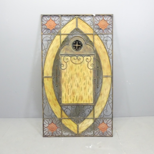 130 - A large wrought-iron and yellow stained glass candle stand wall panel, with allover pierced scrolled... 