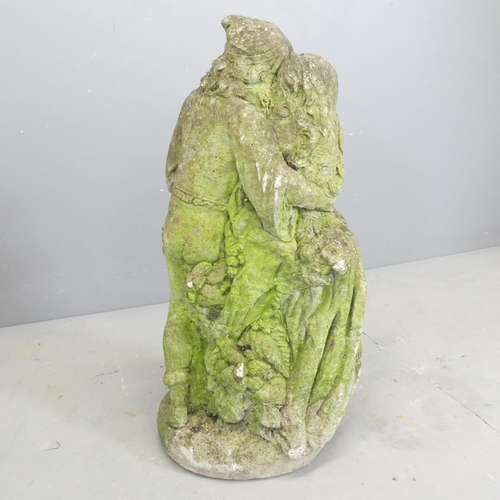 139 - A weathered stone garden statue, study of a dancing couple. Height 68cm.