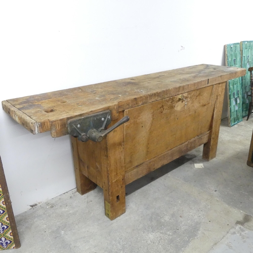 174 - A vintage pine workbench, fitted with vice and fall-front cupboard under. 197x78x58cm.