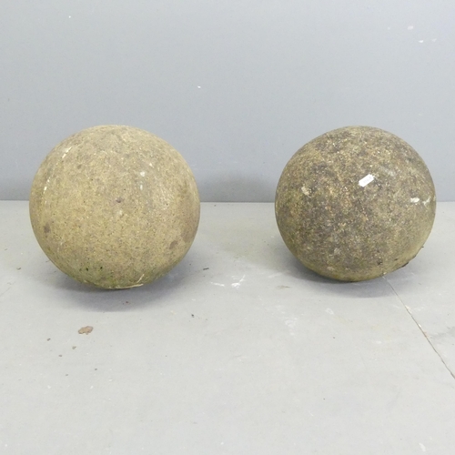 153 - A pair of weathered stone gatepost ball finials. Diameter approximately 31cm.