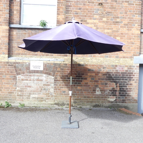 184 - A garden parasol on cast metal base. Approximate height 250cm.