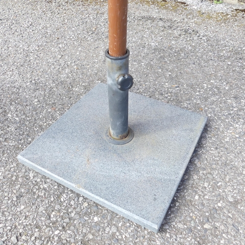 184 - A garden parasol on cast metal base. Approximate height 250cm.