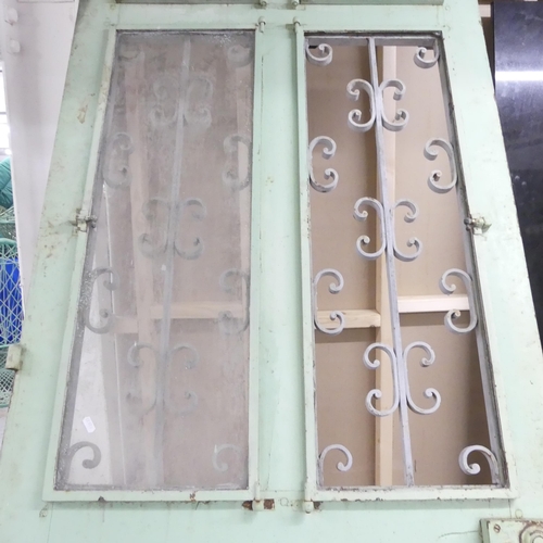 188 - A large panelled arch top door, with opening glass panes and wrought iron decoration. 90x245cm.