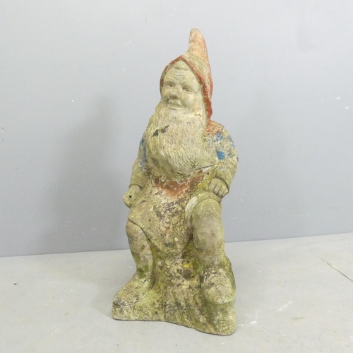 209 - A painted and weathered stone gnome garden ornament. Height 65cm.