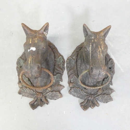 269 - A pair of cast iron door knockers in the form of horse heads. 20x30x14cm.