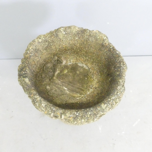 274 - A weathered concrete two-section bird bath, with cherub design base, 31x56cm.