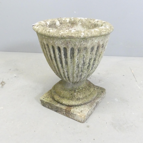 294 - A weathered concrete garden urn with fluted decoration. 31x37cm.