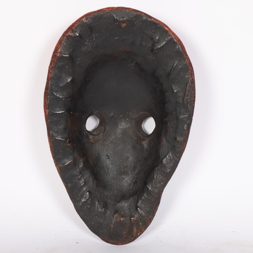 31 - WITHDRAWN  A coloured leather-covered mask with work to decoration, L31cm