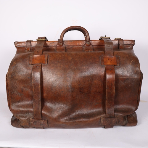 92 - A large Antique leather Gladstone travel bag, with hinged folding sides and leather straps, by John ... 