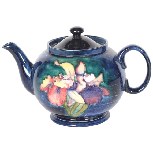 226 - MOORCROFT - a Moorcroft blue ground tube-lined teapot in Orchid pattern