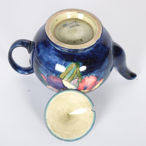 226 - MOORCROFT - a Moorcroft blue ground tube-lined teapot in Orchid pattern