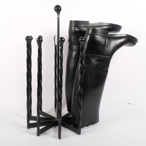 128 - A wrought-iron boot tree stand, and a pair of French black riding boots, size 43, stand height 57cm