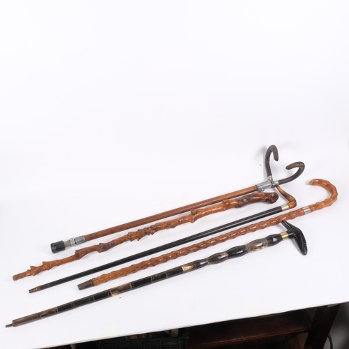 129 - A group of walking sticks, including an early 20th century shooting stick marked A Howard Whites Clu... 