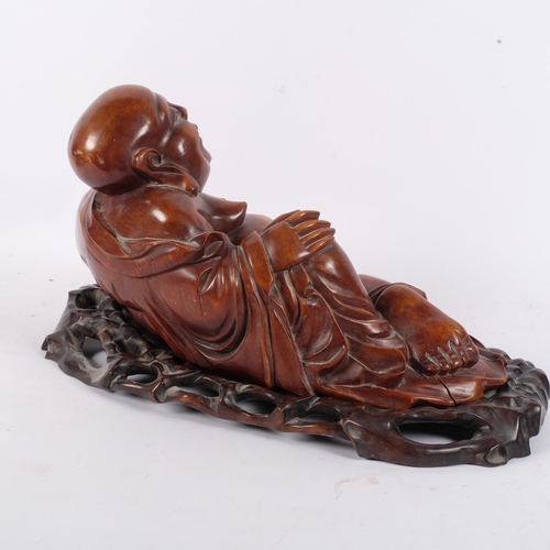 168 - A large carved hardwood reclining Buddha, on fitted stand, overall length 44cm